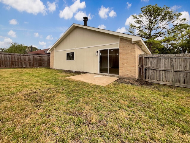 back of house featuring a patio area and a lawn