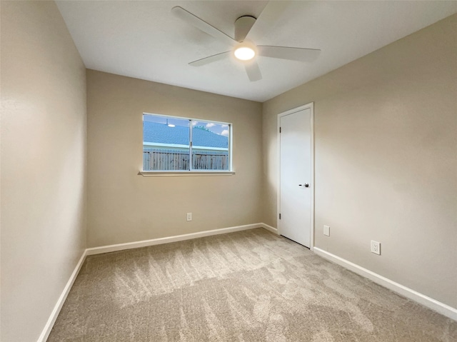 carpeted spare room featuring ceiling fan