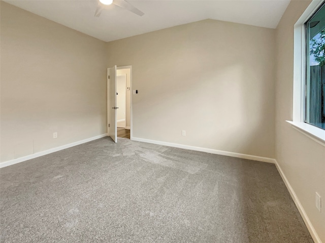 carpeted spare room featuring lofted ceiling and ceiling fan