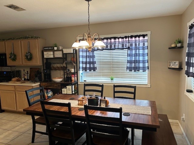 dining area featuring light tile patterned flooring and an inviting chandelier