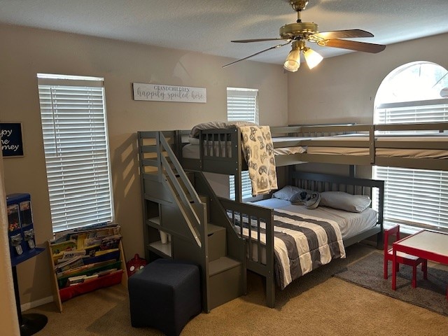 carpeted bedroom with a textured ceiling and ceiling fan