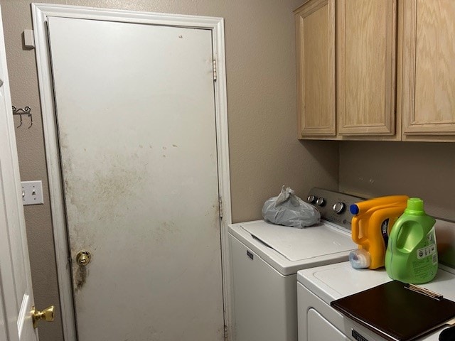 washroom featuring cabinets and separate washer and dryer