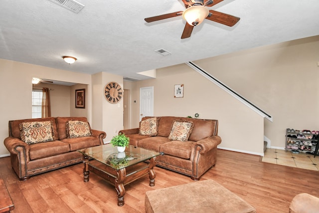 living room with wood-type flooring, a textured ceiling, and ceiling fan