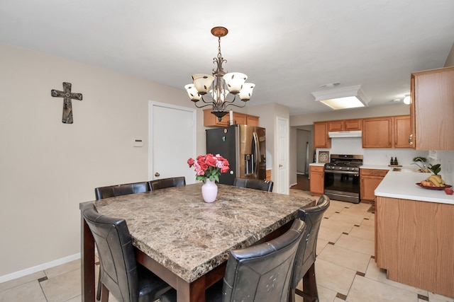 dining space featuring light tile patterned floors, a notable chandelier, and sink