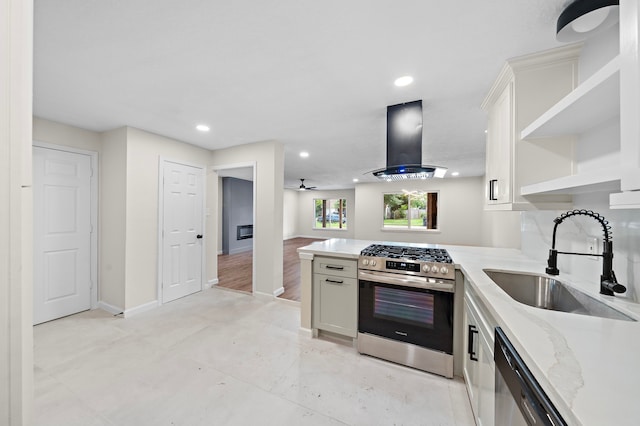 kitchen featuring exhaust hood, kitchen peninsula, stainless steel appliances, sink, and white cabinetry