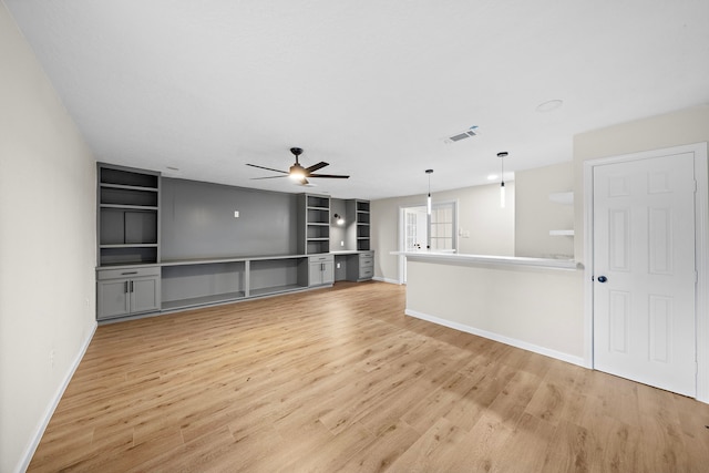 unfurnished living room featuring ceiling fan and light wood-type flooring