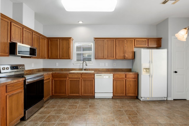 kitchen featuring stainless steel appliances, sink, and light tile patterned flooring