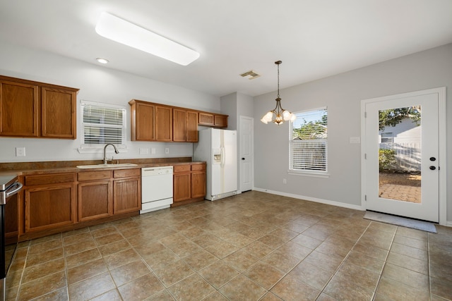 kitchen featuring white appliances, sink, pendant lighting, a notable chandelier, and light tile patterned floors