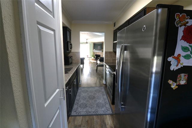 kitchen with dark wood-type flooring, appliances with stainless steel finishes, ornamental molding, and decorative backsplash