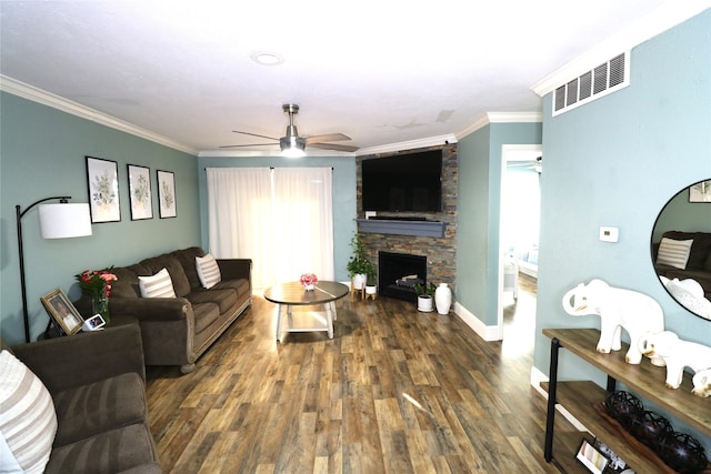 living room with dark wood-type flooring, crown molding, a fireplace, and ceiling fan