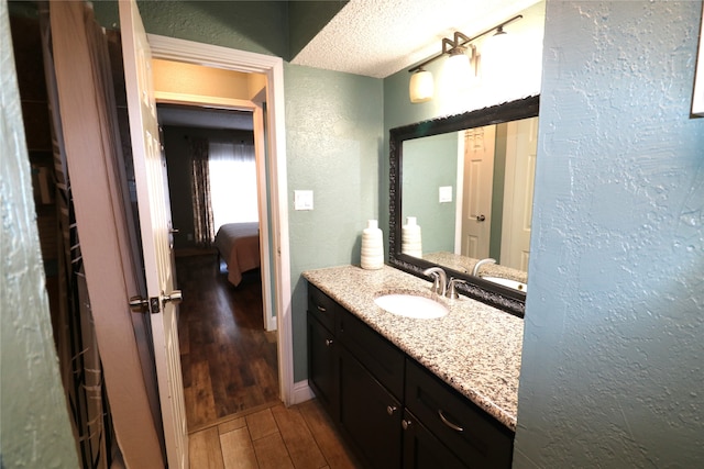 bathroom featuring vanity, hardwood / wood-style flooring, and a textured ceiling