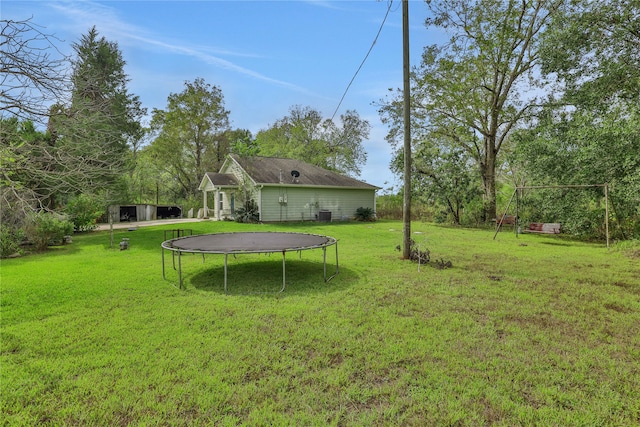 view of yard with central AC and a trampoline