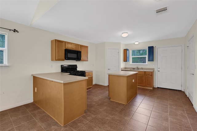 kitchen featuring dark tile patterned floors, kitchen peninsula, sink, black appliances, and a center island