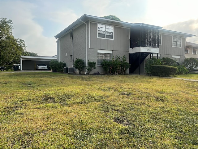 view of side of home featuring central AC, a carport, and a lawn