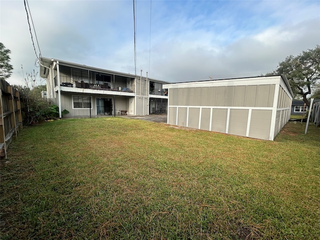 rear view of house with a lawn and a balcony