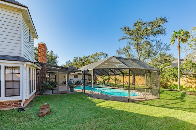 view of pool with a lanai and a lawn