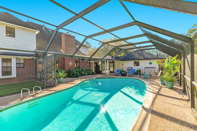 view of swimming pool featuring glass enclosure and a patio area