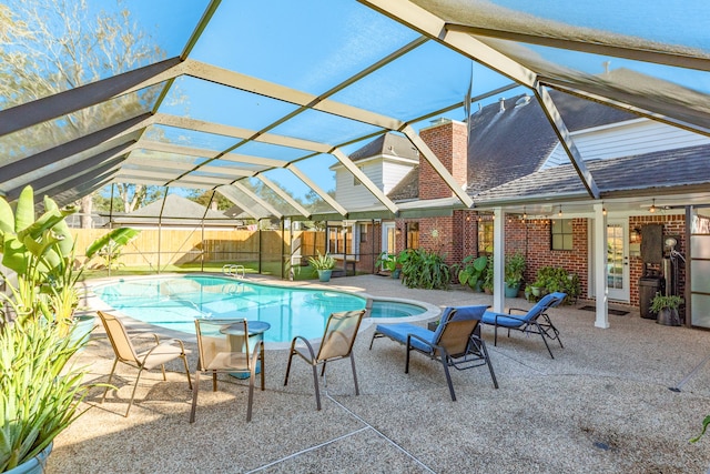 view of pool with glass enclosure and a patio area