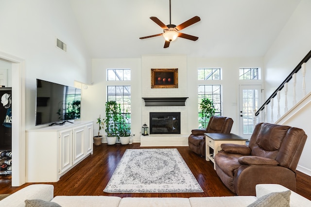 living room with plenty of natural light, high vaulted ceiling, and dark hardwood / wood-style floors