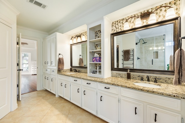 bathroom with crown molding, tile patterned flooring, vanity, and walk in shower