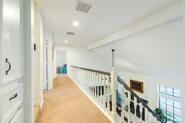 hallway with light carpet and lofted ceiling with beams