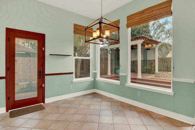 unfurnished dining area with a notable chandelier and tile patterned floors