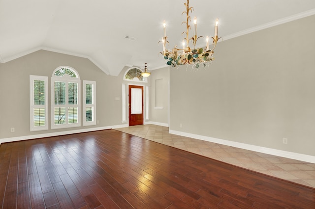 entryway with light hardwood / wood-style floors, a notable chandelier, ornamental molding, and lofted ceiling