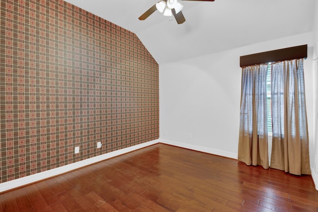 empty room featuring ceiling fan, lofted ceiling, and dark hardwood / wood-style floors