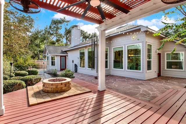 deck with an outdoor fire pit, a patio area, ceiling fan, and a pergola