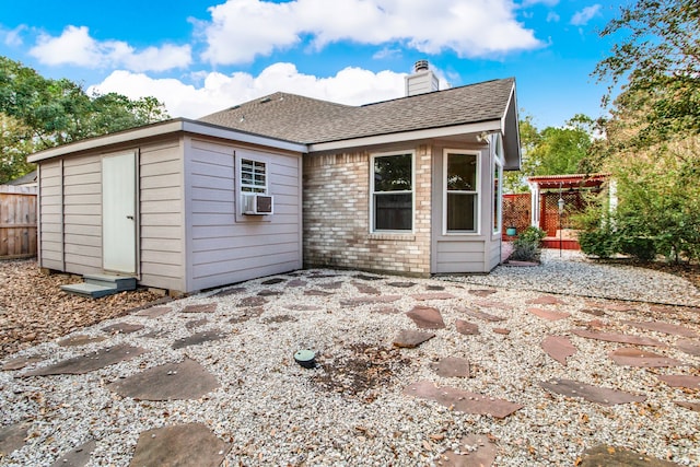 back of property featuring a shed and a patio