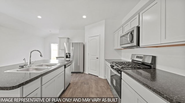 kitchen with light hardwood / wood-style floors, sink, white cabinetry, a kitchen island with sink, and stainless steel appliances