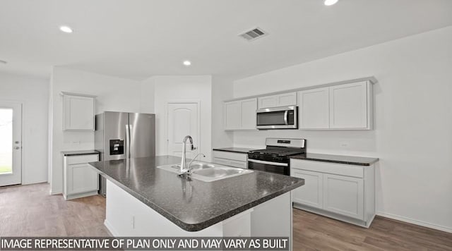 kitchen with an island with sink, stainless steel appliances, white cabinets, light hardwood / wood-style flooring, and sink