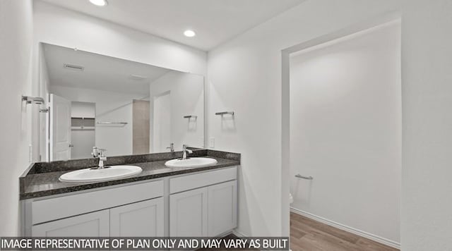 bathroom with toilet, hardwood / wood-style floors, and vanity