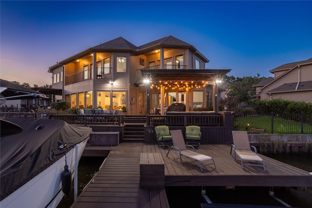 back house at dusk featuring a balcony