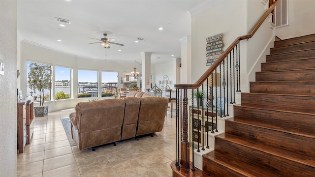 tiled living room featuring crown molding and ceiling fan with notable chandelier