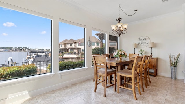 tiled dining area with a notable chandelier, ornamental molding, and a water view