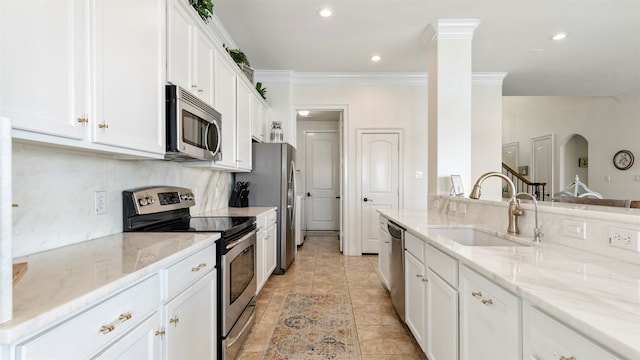 kitchen featuring light stone countertops, appliances with stainless steel finishes, sink, and white cabinets