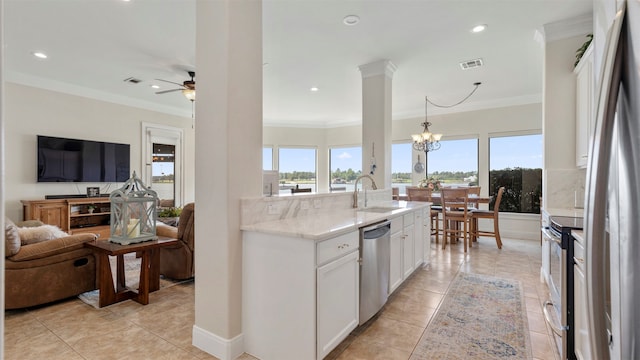 kitchen with sink, stainless steel appliances, decorative light fixtures, white cabinets, and ornamental molding