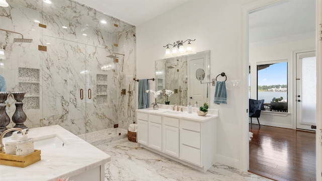 bathroom with wood-type flooring, ornamental molding, vanity, an enclosed shower, and a water view