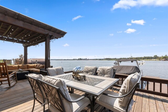 wooden deck with a water view and outdoor lounge area