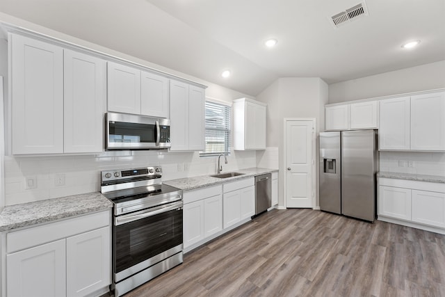 kitchen featuring white cabinetry, appliances with stainless steel finishes, sink, and light wood-type flooring