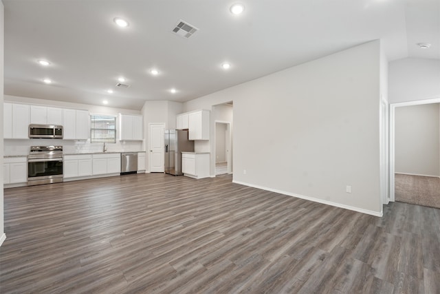 unfurnished living room featuring hardwood / wood-style flooring and vaulted ceiling