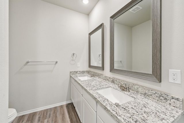 bathroom with vanity, wood-type flooring, and toilet