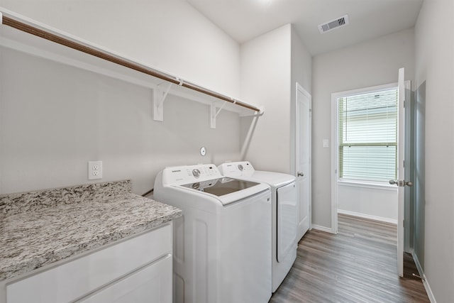 laundry area featuring light hardwood / wood-style flooring and washing machine and dryer