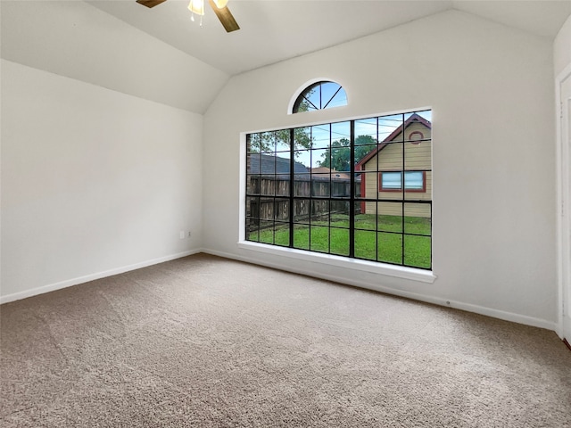 empty room with a wealth of natural light, lofted ceiling, and carpet flooring