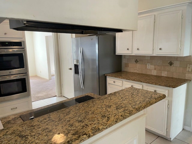 kitchen with white cabinets, dark stone countertops, appliances with stainless steel finishes, and tasteful backsplash