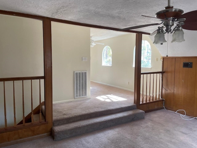 interior space with ceiling fan, light colored carpet, and a textured ceiling