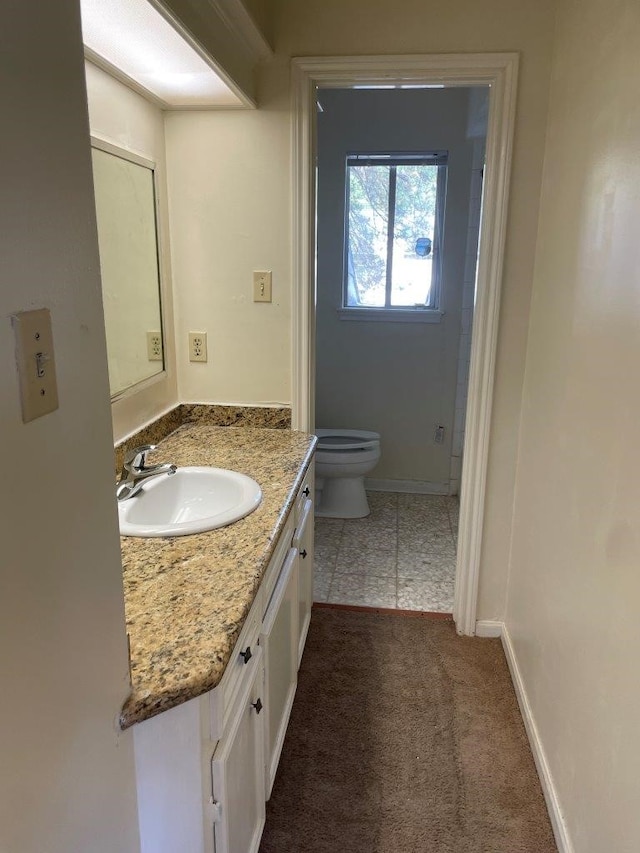 bathroom with tile patterned flooring, vanity, and toilet