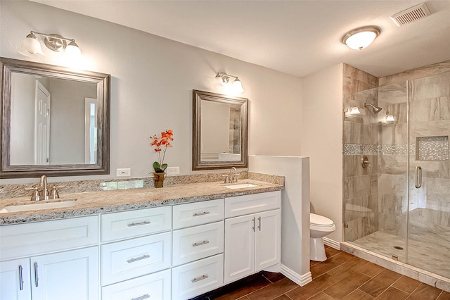 bathroom with vanity, an enclosed shower, and toilet