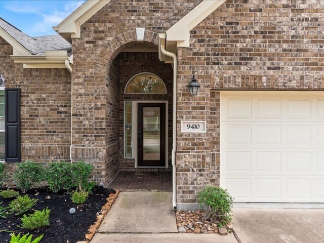 9410 Trinity Trail Ct, Cypress, TX 77433 - entrance to property with a garage, driveway, and brick siding
